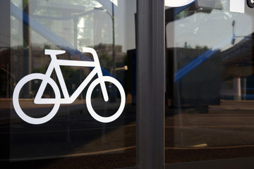 Bicycle icon on automatic glass bus door. Public transport equipped to bicyclist convenience. Intercity tourist bus adapted for transporting bicycles over long distances.
