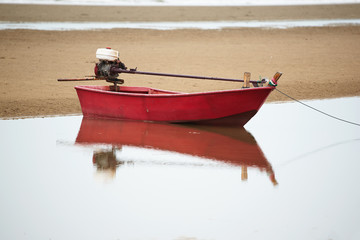 A red fisherman long-tail boat on the beach