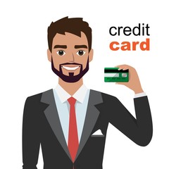 Young man smiling, showing, presenting credit card for making paymen.