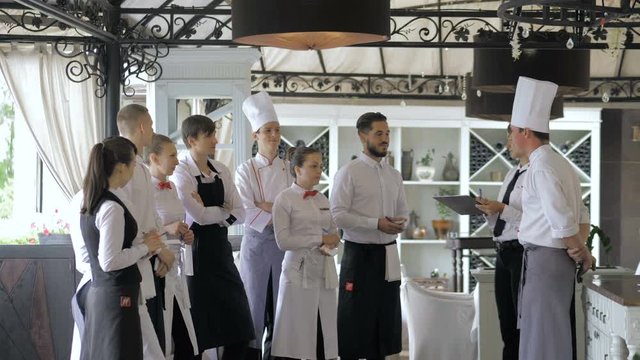 Restaurant manager and his staff in terrace. Interacting to head chef in restaurant