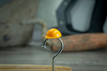 Carpentry nail shaped as question mark and helmet