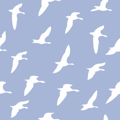 Cotton fabric The seamless pattern with white silhouettes of flying birds is on blue background.