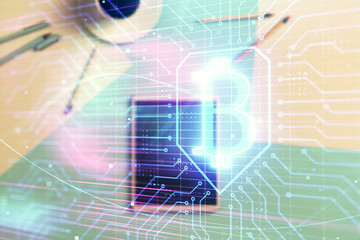 Double exposure of bitcoin drawing on digital tablet on the table background. Concept of blockchain