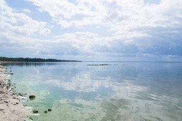 Blue sky with clouds reflected in water. Beautiful seascape.