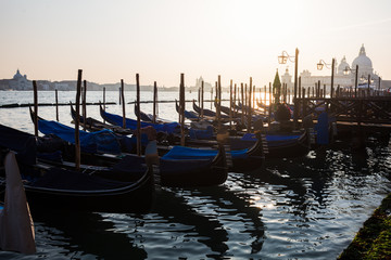 Traditional gondola and The Grand Canal and the Basilica di Santa Maria della Salute in Venice at sunset