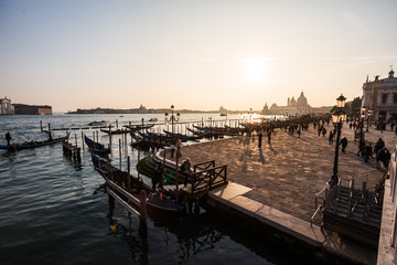 Fototapeta premium Traditional gondola and The Grand Canal and the Basilica di Santa Maria della Salute in Venice at sunset