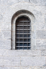 Fototapeta na wymiar antica finestra ad arco con sbarre in ferro battuto, europa
