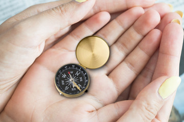 Compass in child’s hands supported by the family, parenting concept