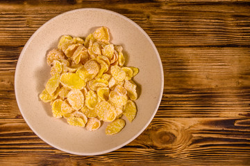 Ceramic plate with cornflakes on a wooden table. Healthy eating. Top view