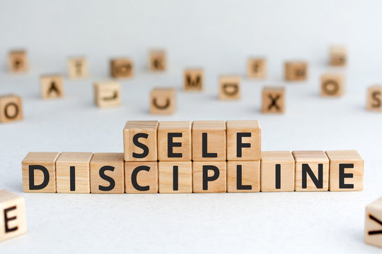 Self discipline - words from wooden blocks with letters, self-discipline concept, random letters around, white  background