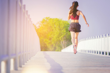 Woman running sprinting on road. Fit female fitness runner during outdoor workout