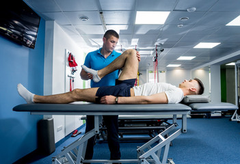 Rehabilitation therapy. Physiotherapist working with young male patient in the rehabilitation center