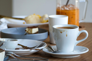 stacks of dirty dishes, plates and cups of finished meal in christmas or new year party waiting to clean at the dining room in house or restaurant