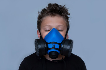 Young boy wearing gasmask, respirator portrait. Effects of worldwide air pollution, industrial...