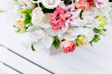 White box with flower bouquet on bench.