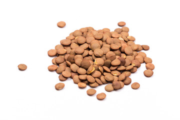 Isolated stack of uncooked lentils on white background from above.