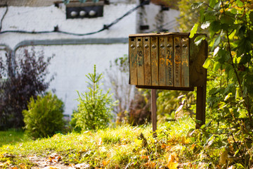 The rusty old mailboxes on the autumn nature. Abandoned iron mailboxes with house numbers.