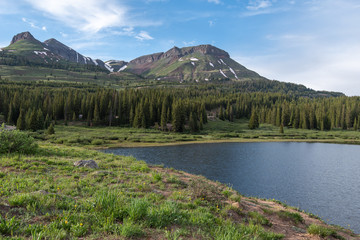 Obraz premium Landscape of little molas lake, forest, and snow-dappled San Juan Mountains