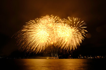 Beautiful colorful fireworks in sky over river. Big festive evening event with great pyrotechnic show.  