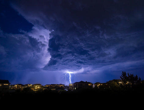 An offshore summer rain squall drops a bolt of lightning onto the ocean just off the coast of corolla north carolina.