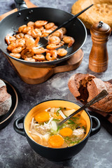 Several dishes on the table: meatball soup, bread, fried shrimp.
