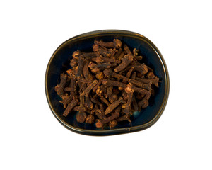 Dry cloves in a bowl isolated on white background. Spice on isolate. View from above.