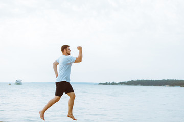 man running by sea beach barefoot