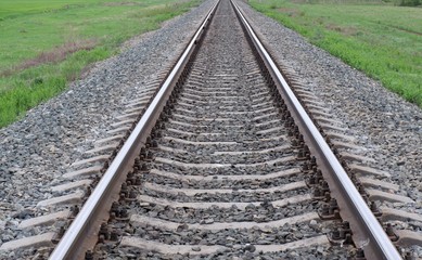 Fototapeta premium railway rails among green grass