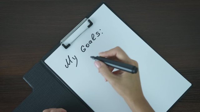 My Goals. Women's hands write down their goals.