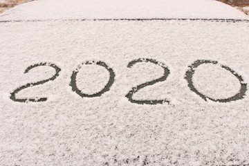 The inscription 2020 on the snow. The inscription on the glass of the car. The concept of a New year.