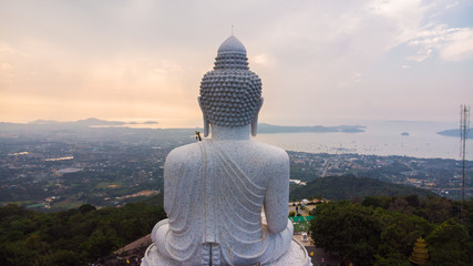 Big white buddhist monk on top of mountain peak sunrise sky aerial view