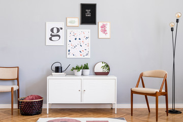 Design scandinavian home interior of open space with mock up posters gallery wall, white shelf, design chair, plants, lamp basket, mirror and elegant accessories. Retro cozy home decor. Template.