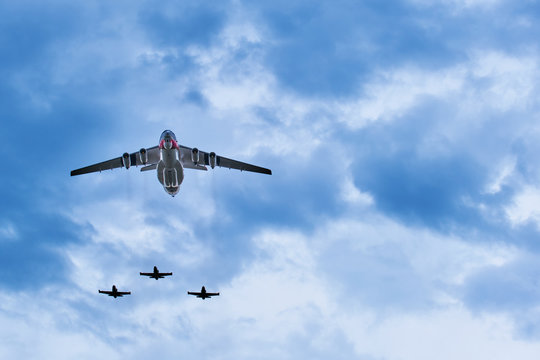Heavy airlifter plane accompanied by three light jet trainers