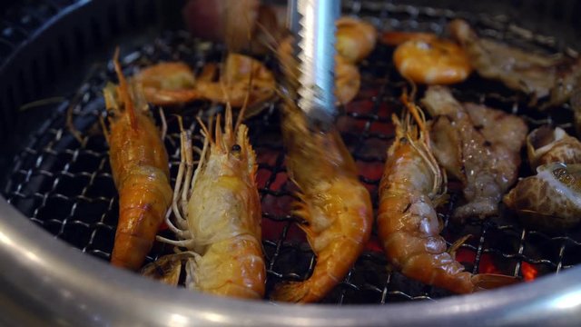 Young asian woman eating seafood yakiniku japanese grilled	