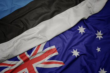 waving colorful flag of australia and national flag of estonia.