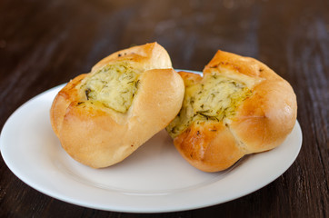 Homemade buns in white plate on wooden background