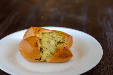 Homemade buns in white plate on wooden background