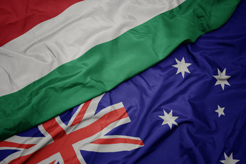 waving colorful flag of australia and national flag of hungary.