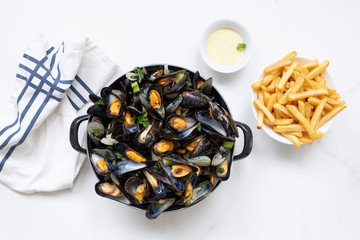 Belgian mussels with potato fries on while marble table overhead view  - obrazy, fototapety, plakaty