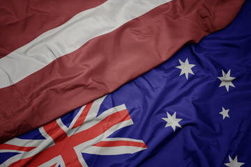 waving colorful flag of australia and national flag of latvia.