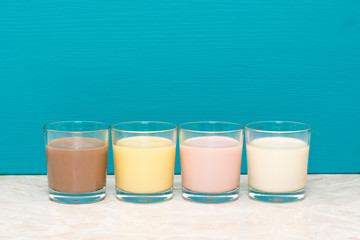 Chocolate, banana and strawberry milkshakes and milk in tumblers