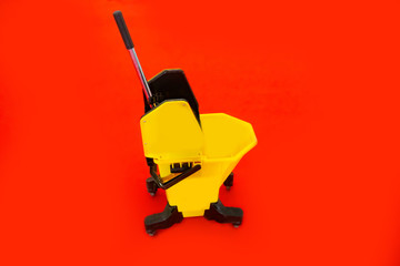 Pail for the floor. Bucket on wheels for mopping. Professional equipment for cleaners. A bucket with a filter for dirt and an extraction. Single bucket cleaning trolley. Yellow trolley floor cleaning