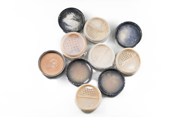 Obraz na płótnie Canvas Close-up of makeup jars filled with loose cosmetic face powder different shades on the white background isolated. Free space for text mockup