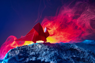 Dragon made of paper. Red Paper Draco Origami. Draco stands in the light of the lava. Metaphor of a...