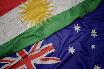 waving colorful flag of australia and national flag of kurdistan.