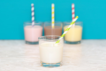 Fresh milk in front of a row of flavoured milkshakes