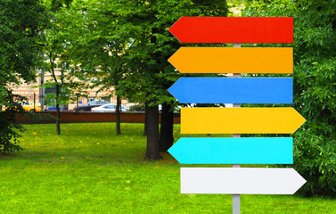 Colorful pointers on the background of the city park. Signpost directional arrows. Direction sign,...