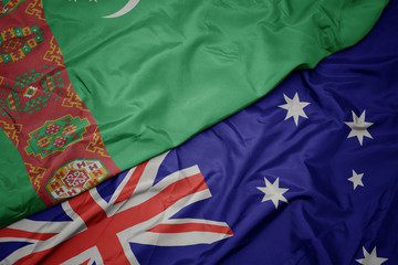 waving colorful flag of australia and national flag of turkmenistan.