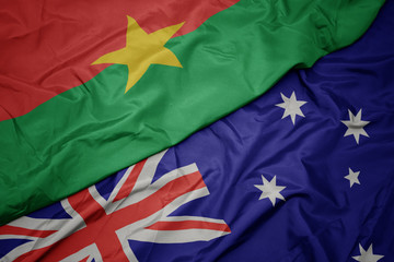 waving colorful flag of australia and national flag of burkina faso.