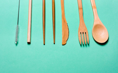 Natural, Organic wooden fork, spoon, cutlery on a green background.